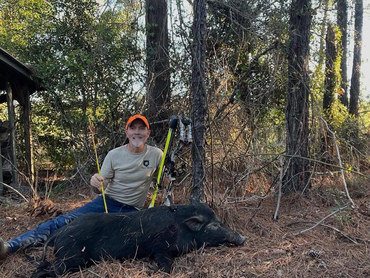 Hunter with a hog taken using Flo-yellow arrows